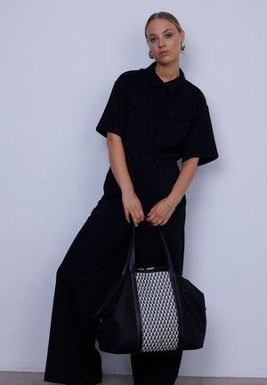 Black tote bag with a textured woven pattern in silver and black. Features two sturdy handles and a zip closure. Adjustable shoulder strap included.