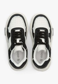 Czarno-białe sneakersy z gładką skórzaną cholewką, perforowanymi palcami i grubą gumową podeszwą. Zawierają markowe srebrne akcenty i sznurówki.