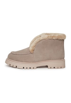 Stivaletti in suede beige con bordo in pelliccia sintetica, punta arrotondata e suola di gomma robusta con scanalature profonde per una buona aderenza.