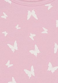 Vaaleanpunainen ribbikangas, jossa on toistuva kuvio valkoisista perhosista eri kokoisina ja suuntina.