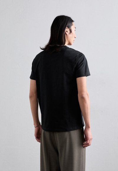 T-shirt noir à manches courtes en coton, avec un design classique à col rond et une coupe décontractée. Texture lisse sans marque visible.