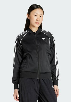 Schwarze Satin-Bomberjacke mit weißen Streifen an Schultern und Ärmeln, mit einem Reißverschluss und Seitentaschen, Logo auf der Brust.