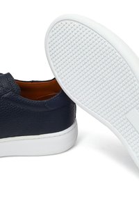 Granatowe skórzane buty wsuwane o fakturowanej powierzchni, z białą gumową podeszwą i gładkim wnętrzem. Charakteryzuje się minimalistycznymi akcentami i detalem logo.