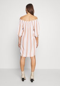 Abito off-the-shoulder con strisce verticali rosa e bianche, maniche ampie, scollatura arricciata e design fino al ginocchio. Tessuto leggero.
