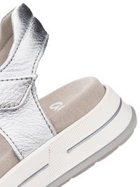 Close-up of silver leather strap sandal with beige cushioned footbed and white textured sole with gray accents.