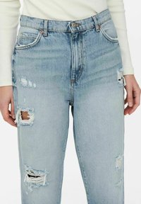 Vaaleansiniset revityt farkut, joissa kulunut ilme ja rispaantuneet reunat, korkea vyötärö ja perinteinen viiden taskun malli.