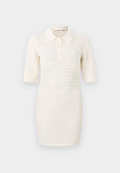 Rochie polo tricotată în nuanță crem, cu mâneci scurte, guler, închidere cu trei butoane și un model cu deschidere în întreaga țesătură.