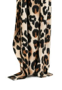 Blanket con stampa leopardata in morbido tessuto beige, caratterizzata da macchie nere e marroni. I bordi sono leggermente sfrangiati, aggiungendo texture al design.