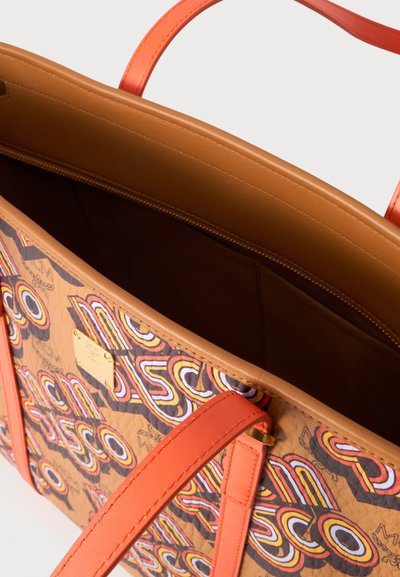 Sac fourre-tout à motifs marron et orange avec poignées orange et ouverture supérieure montrant un intérieur spacieux, vide, doublé de marron.