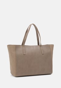 Beige tote bag lavet af glatte og suedematerialer, med to lange håndtag og vertikale syninger.