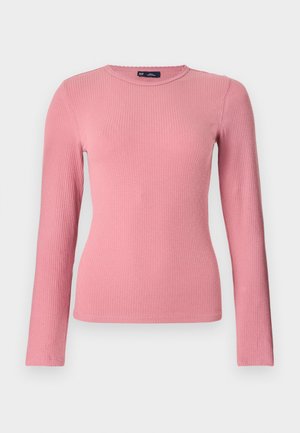 Haut en maille côtelée à manches longues de couleur rose pâle, col rond, coupe ajustée, avec une étiquette de marque GAP visible à l'intérieur du col.
