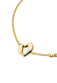 Bracciale in tono dorato con un ciondolo a forma di cuore con un design a ritaglio e le iniziali "MK" sulla catena. Superficie liscia, stile di maglia delicato.