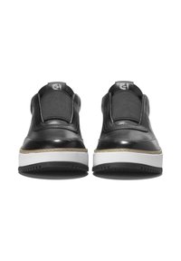 Ein Paar schwarze Slipper mit dicken weißen Sohlen, frontale Ansicht, mit elastischen Stoffeinsätzen und einem kleinen Logo oben.