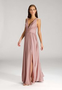 Abito lungo e fluido in morbido tessuto blush, con scollatura a V profonda, vita arricciata e spacco laterale, che mette in risalto la texture liscia e l'elegante caduta.