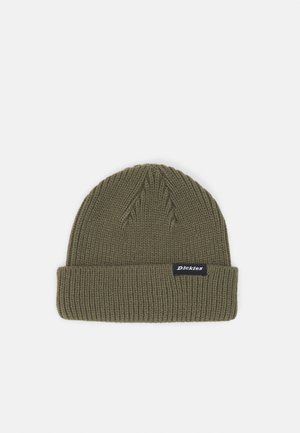 Olivenfarvet strikket beaniehat med en tyk manchet, der har et sort mærke med hvid tekst. Struktureret ribbet mønster over hele hatten.