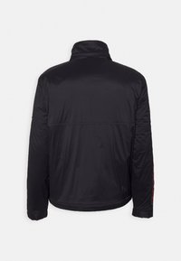 Giacca a vento nera con colletto alto, maniche lunghe e orlo dritto, caratterizzata da cuciture sottili e una texture liscia e lucida.