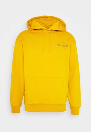 Gele pullover-hoodie met voorvak, trekkoorden en kleine tekst "Since The Original 1873" op de linkerborst.