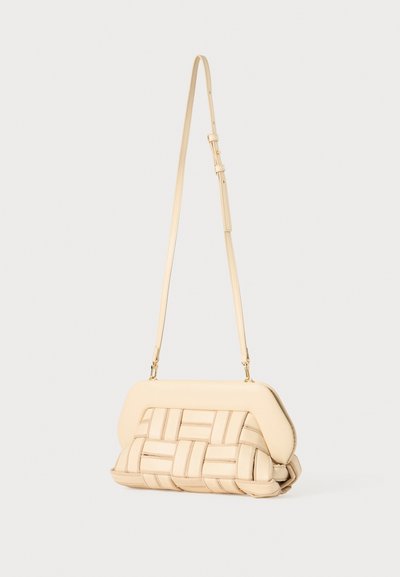 Beige gewebte Umhängetasche aus glattem Leder, strukturierte Form, verstellbarer Tragegurt und auffällige, gesteppte Textur an der Unterseite.