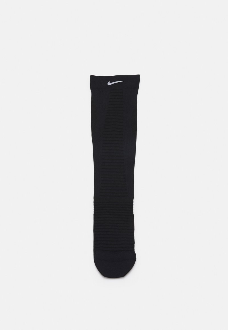 Mustamooduline spordisokk, millel on ribiteksuur ja pehme tallaosa. Ülal on valge Nike logo. Pole nähtavaid mustreid ega aktsente.