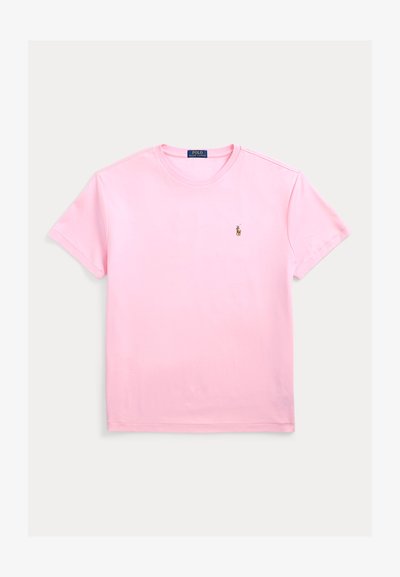 Rožinė medvilninė marškinėliai su apvalia iškirpte ir trumpomis rankovėmis. Ant krūtinės yra maža išsiuvinėta logotipas. Minkšta, lygi tekstūra.