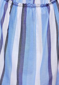 Tessuto a righe con linee verticali di blu chiaro, blu scuro, bianco e grigio. Il materiale sembra leggero, con una consistenza morbida e una parte superiore arricciata.