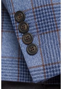 Niebieska kratka materiału zbliżenie na rękaw z czterema ciemnymi guzikami. Wzór składa się z jasnoniebieskich, brązowych i granatowych linii.
