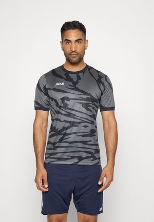 Korte mouw atletisch shirt in een grijs camouflagepatroon, gemaakt van lichtgewicht, rekbaar materiaal. Merkennaam "JAKO" gedrukt in het wit.