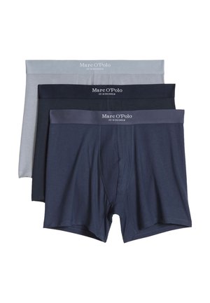 Tres pares de bóxers de hombre en gris, negro y azul marino, cada uno con una cintura con marca que dice "Marc O'Polo EST. IN STOCKHOLM."
