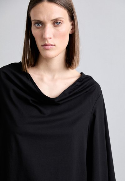 Black draped top with a wide neckline, made of soft fabric. Features relaxed fit and no visible patterns or hardware.
