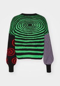 Pull en tricot à base noire, avec des cercles concentriques verts, des spirales rouges et une manche à motif zigzag violet.