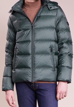 Veste mode verte avec fermeture éclair à l'avant, poches poitrine et latérales, capuche détachable et poignets élastiques. Texture lisse et brillante avec un motif matelassé.