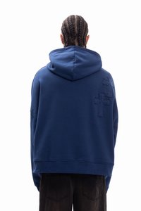 Granatowa bluza z kapturem o przestronnej konstrukcji, wyposażona w kaptur i teksturowane haftowane detale na plecach. Materiał z mieszanki bawełny.