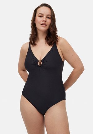 Bañador de una pieza negro con escote en V profundo, acento de anillo en el centro y detalle fruncido en el busto. Tela suave con un diseño ajustado.