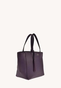 Sac fourre-tout en cuir violet avec surface texturée, double poignées et accent frangé. Design ouvert avec un matériel minimal et des lignes épurées.
