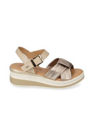 Sandalo con zeppa beige e metallico con punta aperta, cinturino regolabile alla caviglia con fibbia, suola imbottita e design superiore con fasce incrociate.