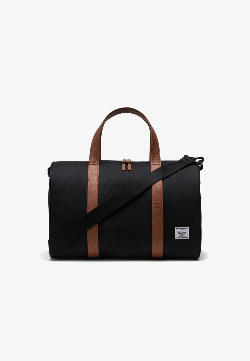 Schwarze Sporttasche mit braunen Lederträgern, Reißverschluss und einem Front-Logo-Patch. Verfügt über einen abnehmbaren Schultergurt für Vielseitigkeit.