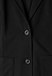 Blazer noir avec deux boutons noirs et deux poches avant, montrant des coutures détaillées et un col à revers cranté.