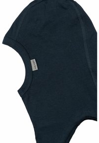 Tumma sininen puuvillainen vauvan hattu, jossa on pehmeä rakenne, pyöreä muoto ja ommeltu kaula-aukko. Sivulla on pieni nimilappu.