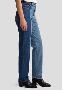 Denim jeans met een mix van donkerblauwe en lichtblauwe secties, recht model en hoge taille. Inclusief een enkele voorkant pocket en stikseldetails.