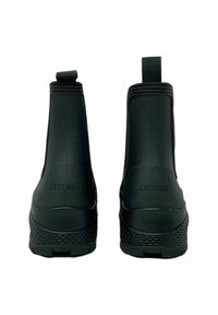 Stivali alla caviglia neri impermeabili con una parte superiore liscia, tacco texturizzato e pannelli laterali elastici per una facile calzata. Logo Skechers sul retro.
