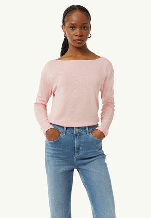 Helles pinkes Langarmshirt mit Bootsausschnitt, aus weichem Stoff, kombiniert mit hochtaillierten blauen Jeans im klassischen Fünf-Taschen-Design.