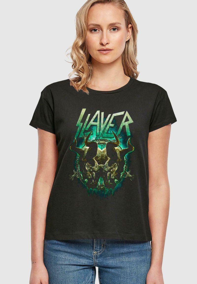 Čierne bavlnené tričko s grafickým dizajnom, na ktorom je lebka a rohy, zvýraznené zelenými a metalickými tónmi, s textom "SLAYER" nad ním.