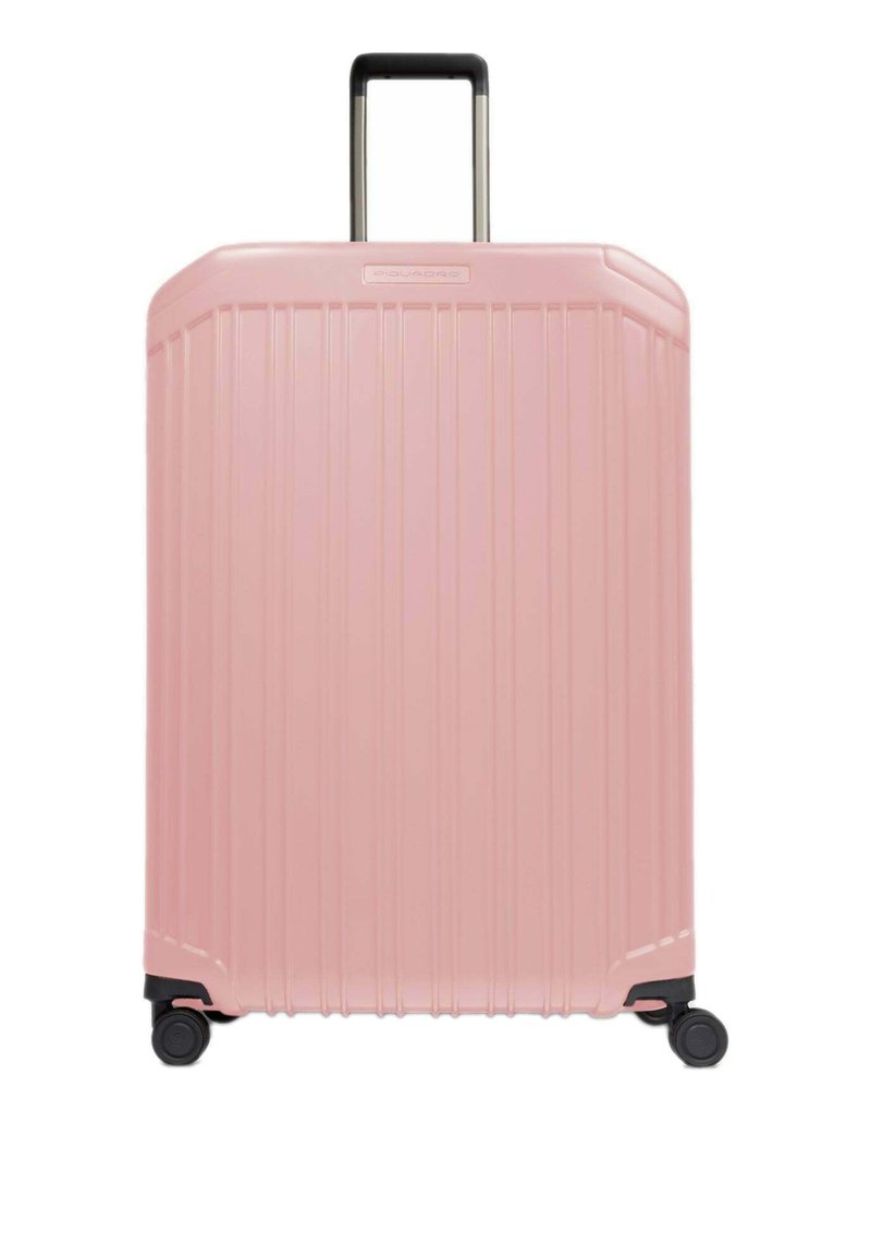 Valigia rigida di colore rosa chiaro, caratterizzata da scanalature verticali, manico retrattile e quattro ruote scorrevoli per una facile manovrabilità.
