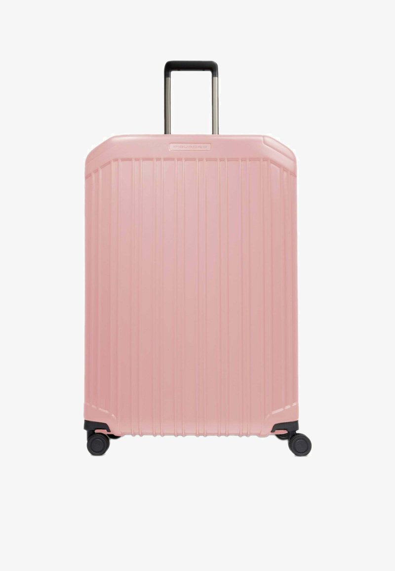 Valigia rigida di colore rosa chiaro, caratterizzata da scanalature verticali, manico retrattile e quattro ruote scorrevoli per una facile manovrabilità.