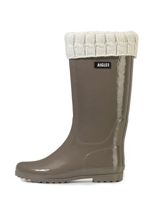 Blank taupe gummistøvle med hvid strikket manchet og Aigle mærke på skaftet.