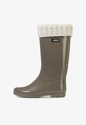 Blank taupe gummistøvle med hvid strikket manchet og Aigle mærke på skaftet.