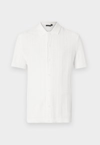 Balta īsām piedurknēm adīta krekla, kas raksturīga ar teksturētu rakstu, norādītu apkakli un piecu pogu aizdari priekšpusē. Gluda auduma apdare.