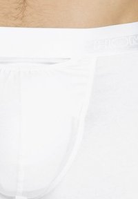 Weiße Herrenunterhosen aus glattem Stoff, mit elastischem Bund, der den Markennamen trägt, und einem konturierten Beutel-Design für optimalen Sitz und Unterstützung.