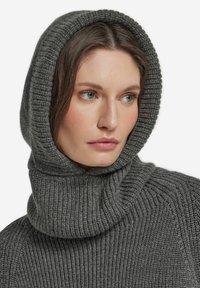 Szary prążkowany sweter z wysokim, podwiniętym kapturem. Tekstura jest miękka, a tkanina ma delikatny połysk, z subtelnymi szczegółami przeszyć na ramionach.