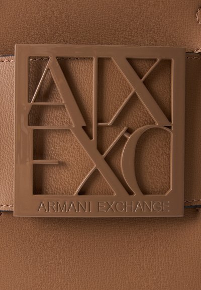 Primer plano de un cinturón de cuero marrón con una hebilla cuadrada que muestra letras recortadas formando "A|X" y "Armani Exchange" embossadas debajo.